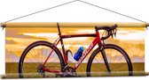 WallClassics - Textielposter - Rode Racefiets in Landschap - 90x30 cm Foto op Textiel