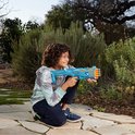 Jongen knielt buiten en houdt een blauwe Nerf Elite Tetrad blaster vast, met oranje darts zichtbaar.