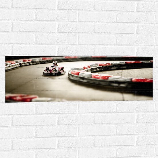WallClassics - Muursticker - Karter op Indoor Kartbaan - 90x30 cm Foto op Muursticker