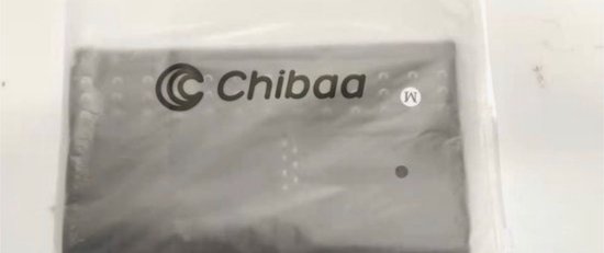 Grijze Chibaa kniebrace in verpakking met merklogo en maat 'M'.