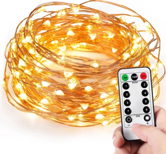 Koperkleurige LED-lichtsnoeren in een bundel, met een hand die een afstandsbediening vasthoudt.