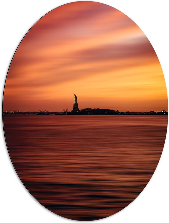 WallClassics - Dibond Ovaal - Oranje Lucht boven Vrijheidsbeeld in New York - 72x96 cm Foto op Ovaal (Met Ophangsysteem)