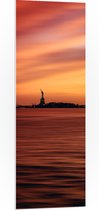 WallClassics - PVC Schuimplaat - Oranje Lucht boven Vrijheidsbeeld in New York - 40x120 cm Foto op PVC Schuimplaat (Met Ophangsysteem)