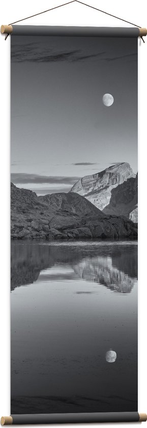 WallClassics - Textielposter - Persoon op Rotsen langs Water met Maan in zwart-wit - 40x120 cm Foto op Textiel