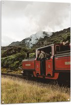 Tuinposter – Oude Machinist op Traditionele Rode Trein door Landschap - 80x120 cm Foto op Tuinposter (wanddecoratie voor buiten en binnen)