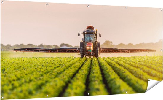 Gards Tuinposter Rode Tractor op het Veld aan het Sproeien - 200x100 cm - Tuindoek - Tuindecoratie - Wanddecoratie buiten - Tuinschilderij