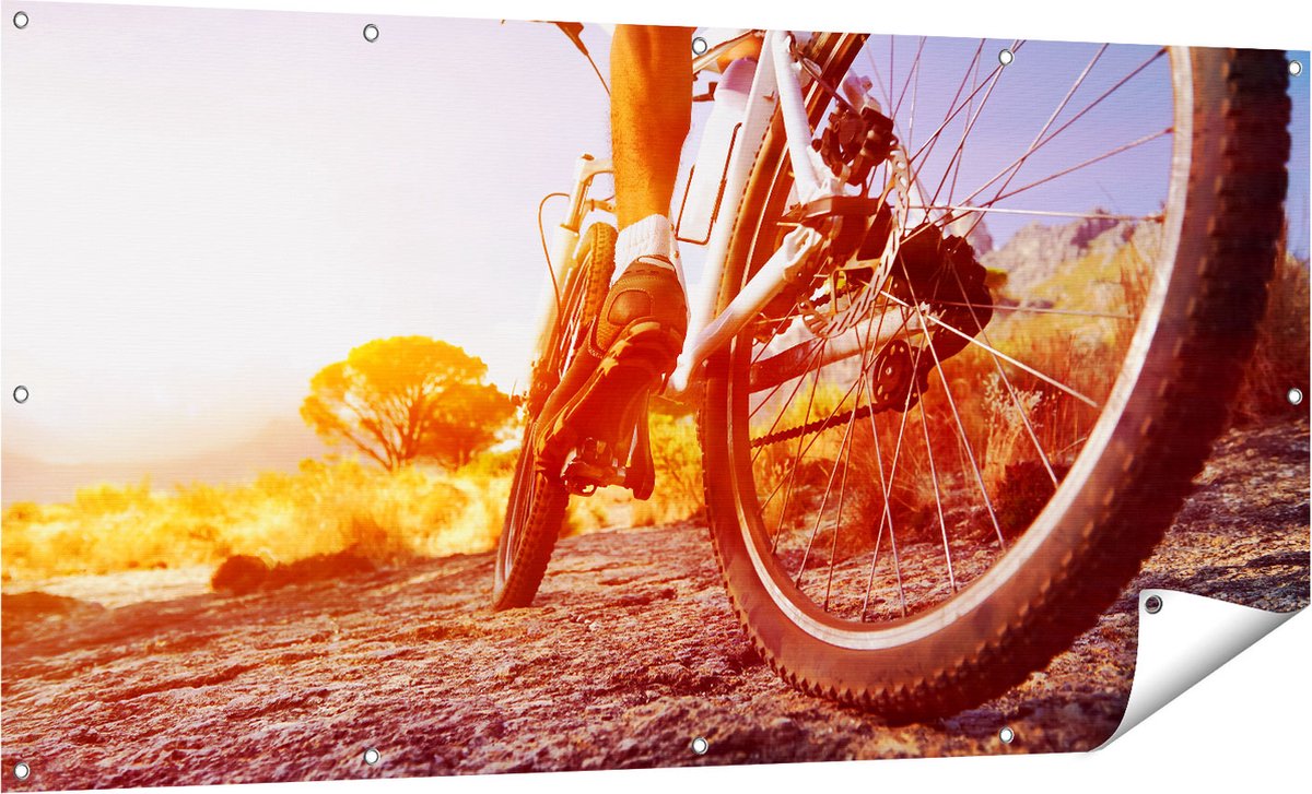 Gards Tuinposter Mountainbike Fietser op Stenen bij Zonsopgang - 160x80 cm - Tuindoek - Tuindecoratie - Wanddecoratie buiten - Tuinschilderij Multikleur