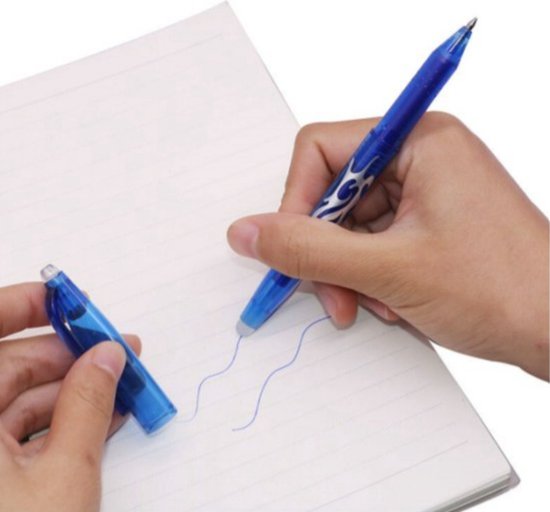 Hand die met een blauwe uitwisbare pen met vlammenpatroon schrijft, de dop ligt ernaast.