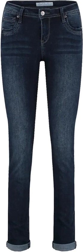 Donkerblauwe skinny jeans met lichte wassing en opgerolde broekspijpen, op een witte achtergrond.