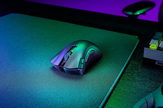 Een gedetailleerde close-up van de donkergrijze Razer Deathadder V2 X HyperSpeed gamingmuis op een zwart gamingmuismat.