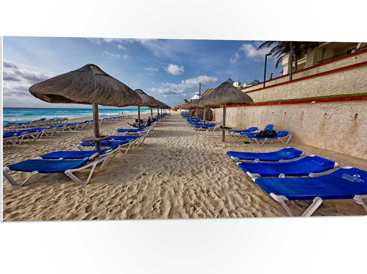 PVC Schuimplaat- Blauwe Ligbedden op Strand met Rieten Parasols - 100x50 cm Foto op PVC Sc