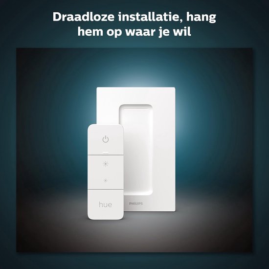 Witte Philips Hue dimmer switch en adapter gemonteerd op een muur.