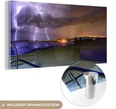 MuchoWow® Glasschilderij 40x20 cm - Schilderij acrylglas - Bliksemflitsen tijdens een zonsondergang - Foto op glas - Schilderijen