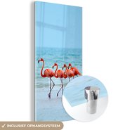 MuchoWow® Glasschilderij 80x160 cm - Schilderij acrylglas - Vier flamingo's staan op het strand - Foto op glas - Schilderijen