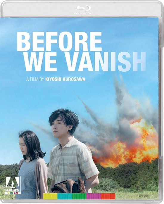 Voorpagina van de Blu-ray: "Before We Vanish" met een stel dat voor een explosie op de achtergrond staat. Blauwe lucht.