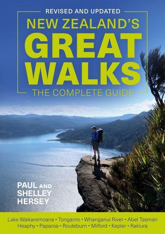 Boek "New Zealands Great Walks: The Complete Guide" met wandelaar op klif uitzicht over een meer.