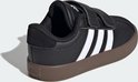 Zwarte Adidas sneaker met witte strepen, klittenband en bruine zool, gezien vanaf de achterkant.