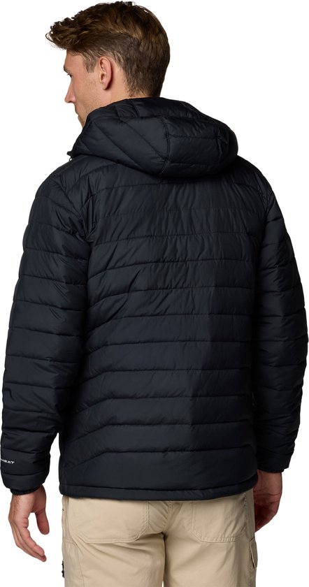 Zwarte gewatteerde Columbia jas met capuchon, achterkant, met beige broek.