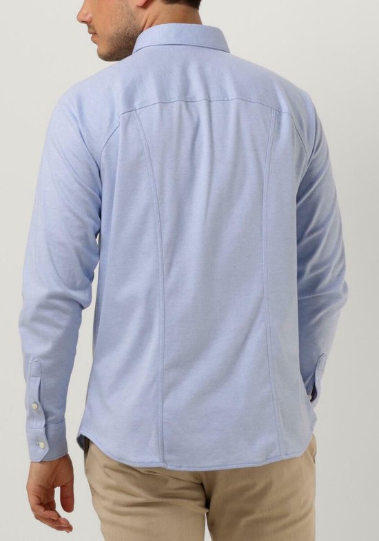 Homme vu de dos portant une chemise bleu clair unie à manches longues. Le dos de la chemise présente deux pinces de couture et les poignets sont boutonnés.