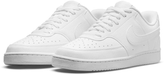 Paar witte leren Nike Court Vision Low Next Nature damessneakers, gezien van de zijkant met veters en perforaties.