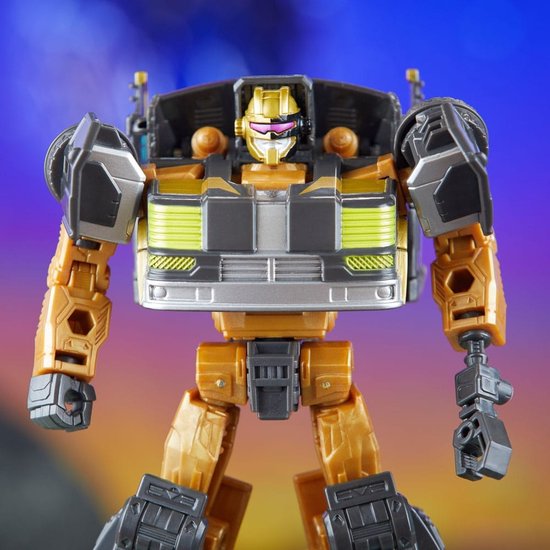 Transformers figuur in goud, zwart en zilver met gele accenten, met een gouden helm en roze vizier.