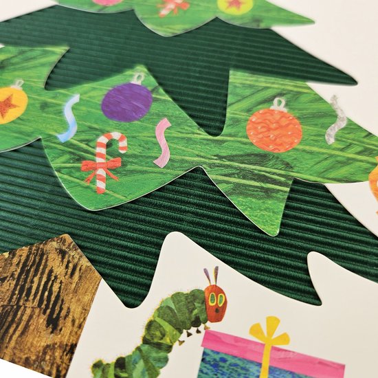 Gedetailleerd van een kerstboom en Rupsje Nooitgenoeg die een cadeau vasthoudt.