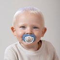 Baby met lichte huid en blonde haren met een lichtblauwe Difrax lovi fopspeen met vosje.