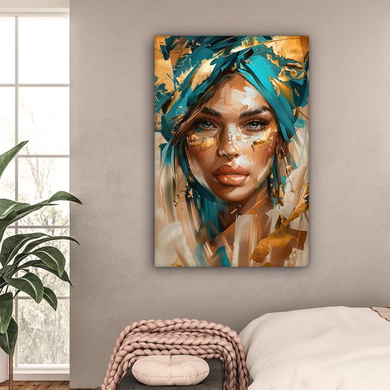 Schilderij van een vrouw met blauwe tulband en gouden verfspatten, hangend boven een bed.