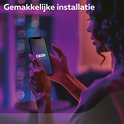 Een vrouw die een smartphone vasthoudt met het Calex Smart Home logo, op paarse achtergrond.