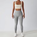Grijze sportlegging met hoge taille, geribbelde tailleband en mesh details op de kuiten.