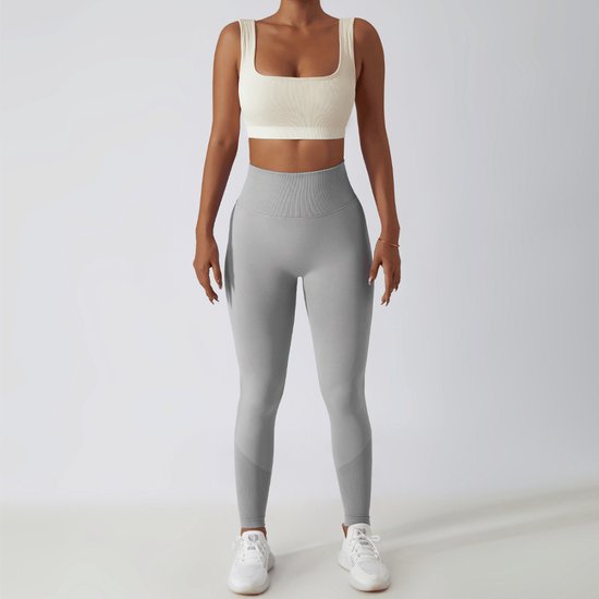 Grijze sportlegging met hoge taille, geribbelde tailleband en mesh details op de kuiten.