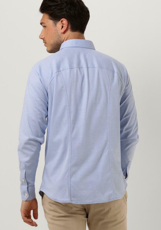Homme portant une chemise bleu clair unie à manches longues. Le dos de la chemise présente des pinces de couture.