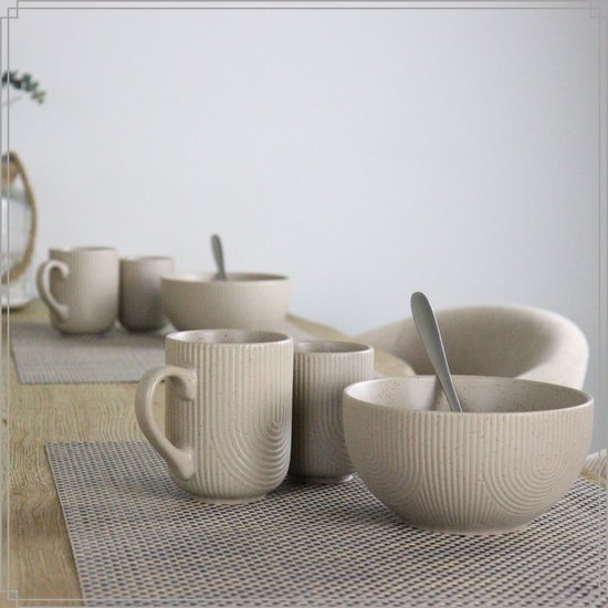 Mise en place de table avec des tasses et un bol blanc cassé à motif côtelé, sur des sets de table.