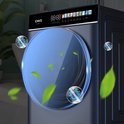 Machine à laver bleu foncé avec une grande porte ronde en verre. Deux bulles avec une icône de virus et des feuilles flottent autour de la machine.