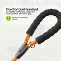 Dichtbij de oranje hondenriem met zwart patroon en zacht, gevoerd handvat.