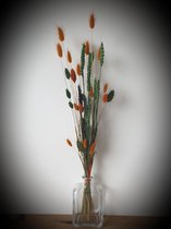 Droogbloemen in decoratieve glazen fles.