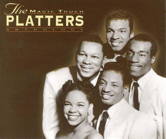 Groepsfoto van The Platters: vier mannen en één vrouw, allemaal in nette pakken, lachend naar de camera.