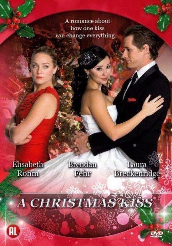 Een poster voor de film 'A Christmas Kiss'. Drie mensen in feestelijke kleding met kerstversiering op de achtergrond. 'A romance about how one kiss can change everything...' staat bovenaan.