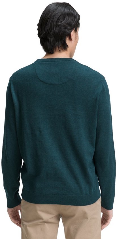 Man van achteren in donkergroene trui en beige chino.