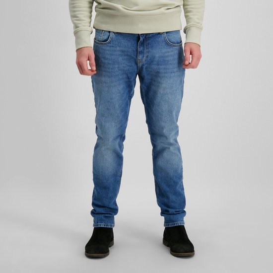 Mannequin portant un jean bleu délavé clair et des chaussures noires. Le jean a une fermeture boutonnée.