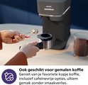 Hand vult de portafilter van de Philips Baristina met gemalen koffie.