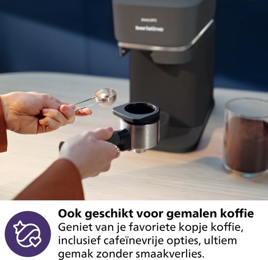 Hand vult de portafilter van de Philips Baristina met gemalen koffie.