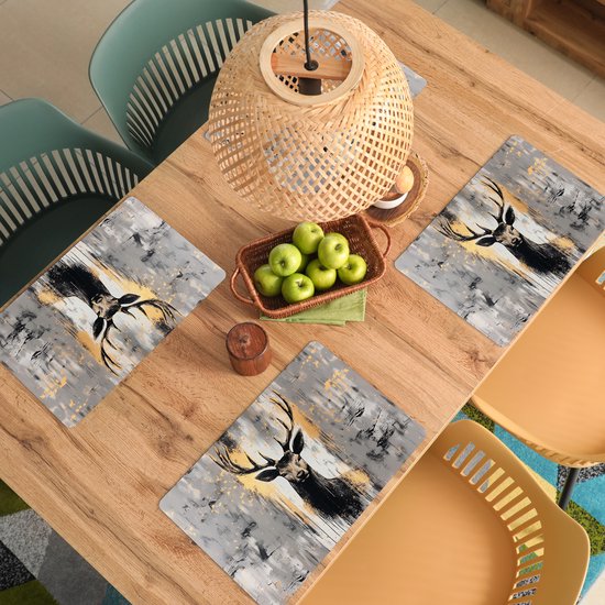 Quatre sets de table avec un cerf abstrait aux bois dorés sur fond gris.
