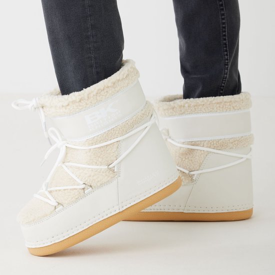 Witte dames moonboots van British Knights met beige suède en teddy voering, gedragen met een grijze jeans.