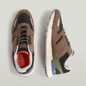 Bovenaanzicht van twee sneakers in beige, zwart en groen met oranje voering en G-Star merkdetails.