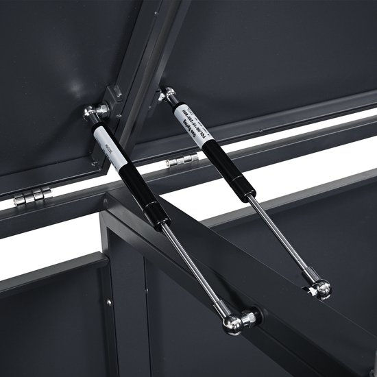 Detail van de gasveren voor de deksels van een grijze containerberging.