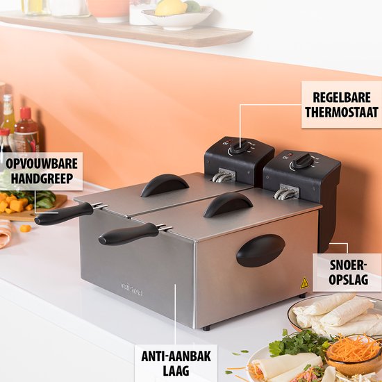 Zilverkleurige dubbele frituurpan met zwarte handgrepen, op een aanrecht met keukenachtergrond.
