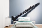 Behang - Fotobehang Een klarinet op een grijze ondergrond - Breedte 330 cm x hoogte 240 cm