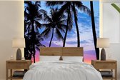Behang - Fotobehang De kleurrijke zonsondergang achter een rij met palmbomen op Hawaï - Breedte 240 cm x hoogte 240 cm