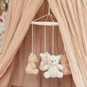 Bruine en beige teddyberen mobiel hangend onder een roze hemeltje.